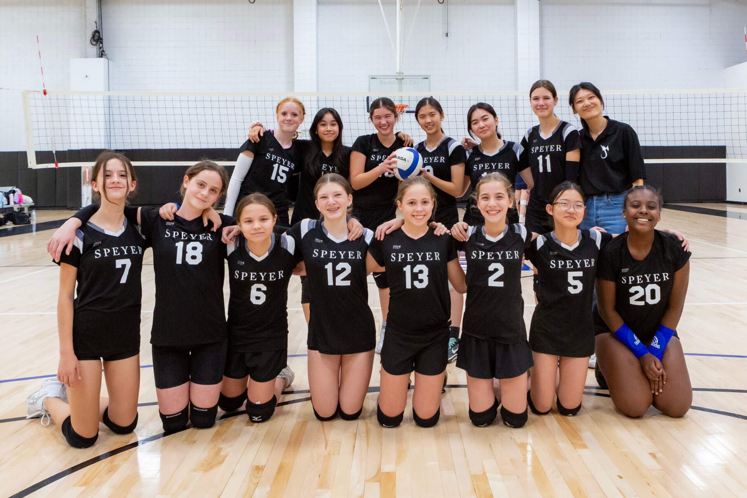Group photo of volleyball team and coach.